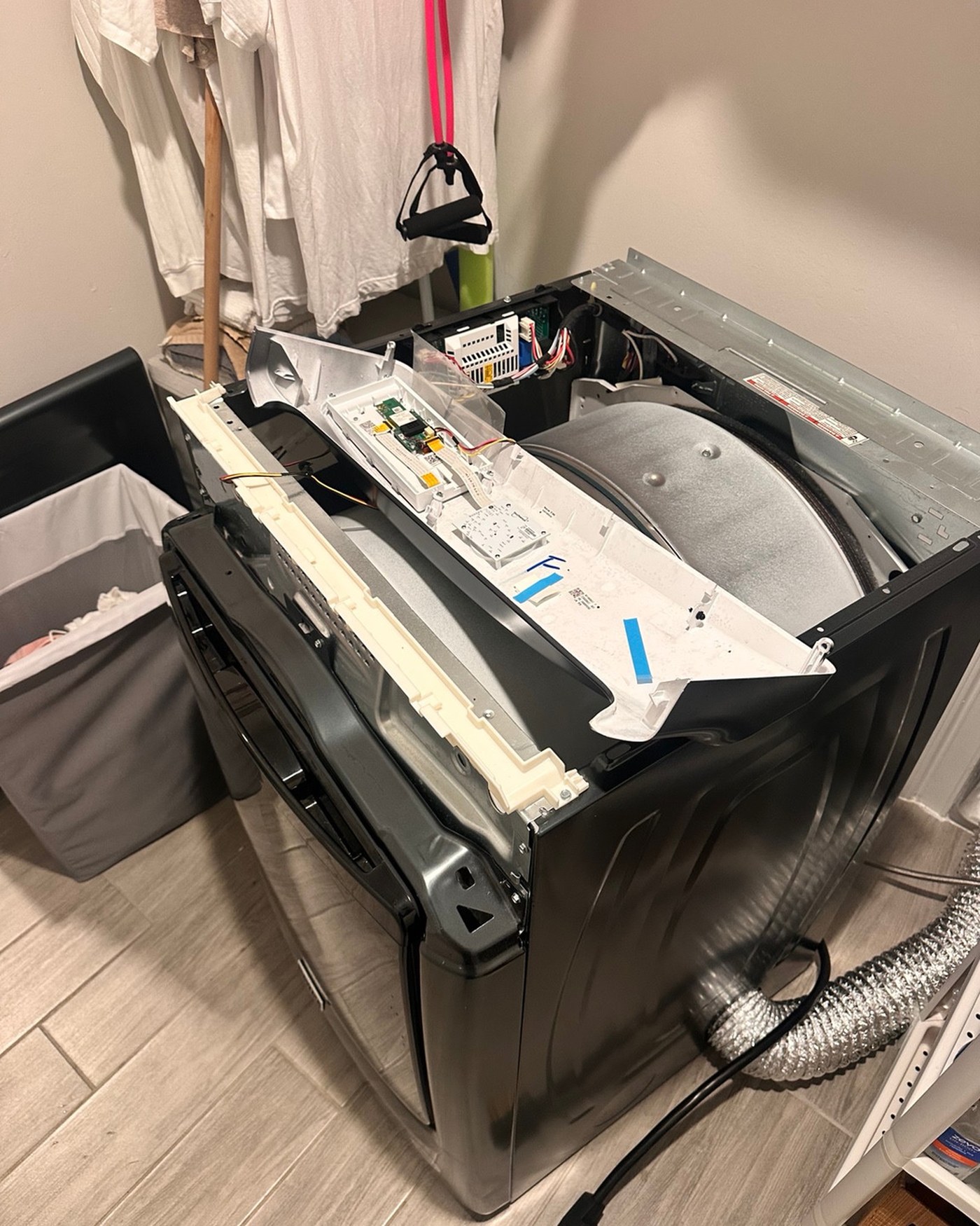Dryer with its control console opened and drum exposed.