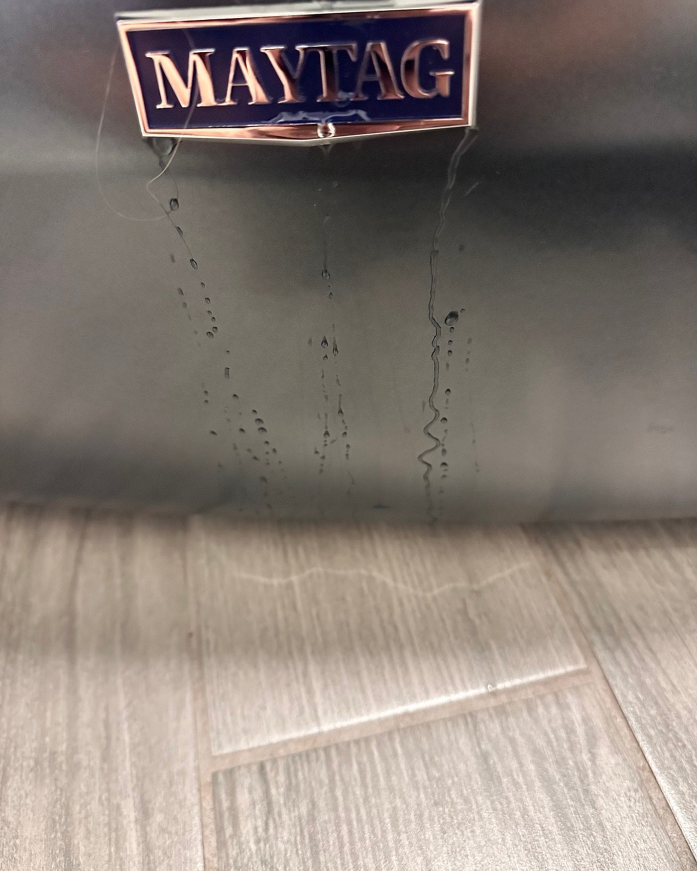 Maytag badge on the front of the dryer.