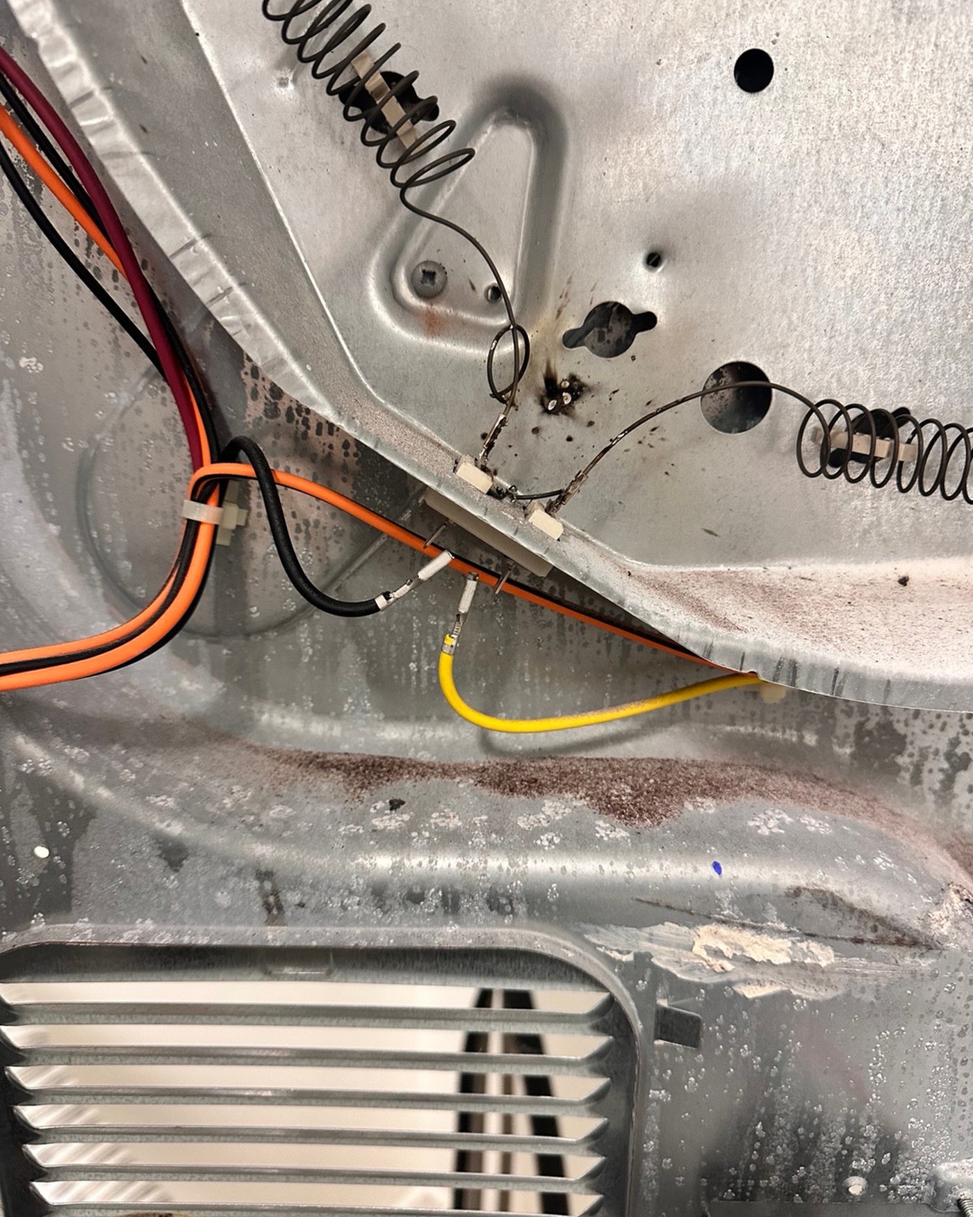 Dryer heating element assembly and surrounding metal housing.