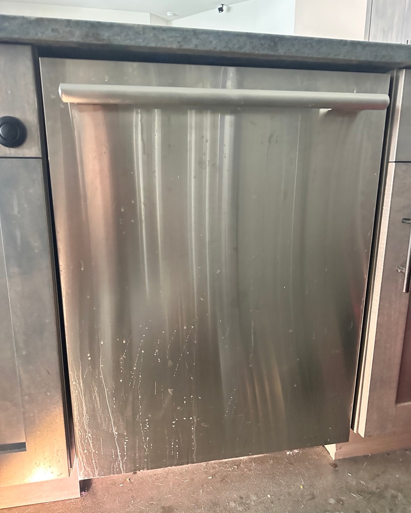 Stainless steel Thermador dishwasher beneath the kitchen counter.