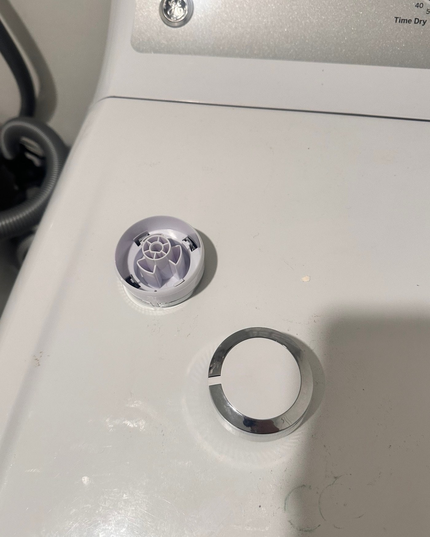 Dryer timer knob pieces resting on the appliance top.