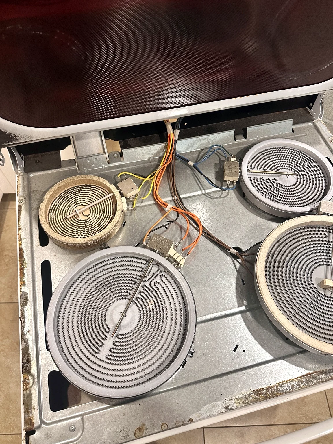 Electric range cooktop opened for dual radiant burner diagnosis in Cape Coral Florida