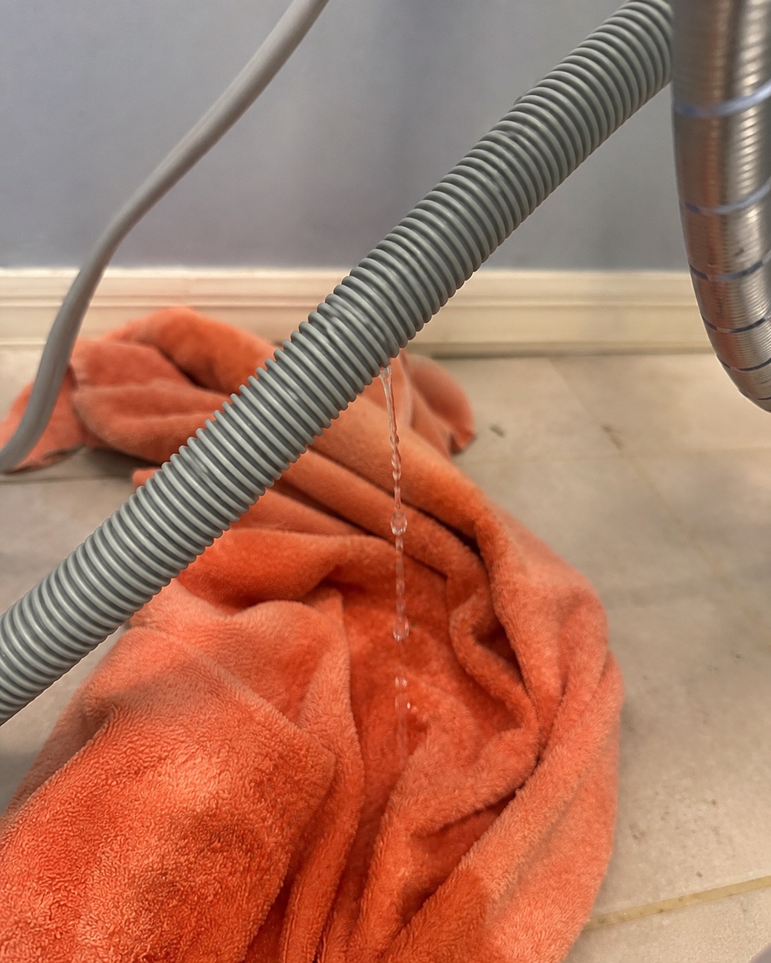 Damaged washer drain hose leaking water before replacement in Estero Florida