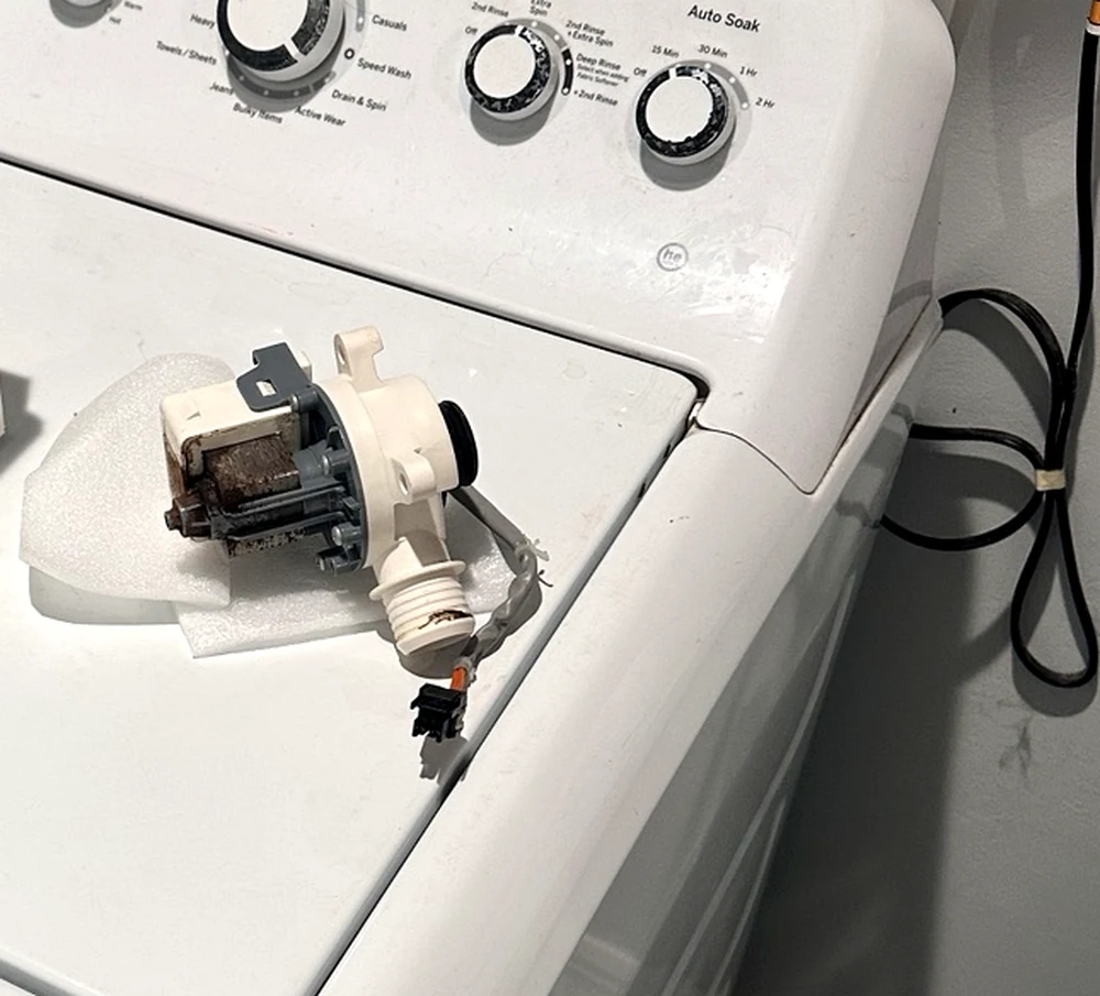 Close view of the GE washer drain pump replaced during repair
