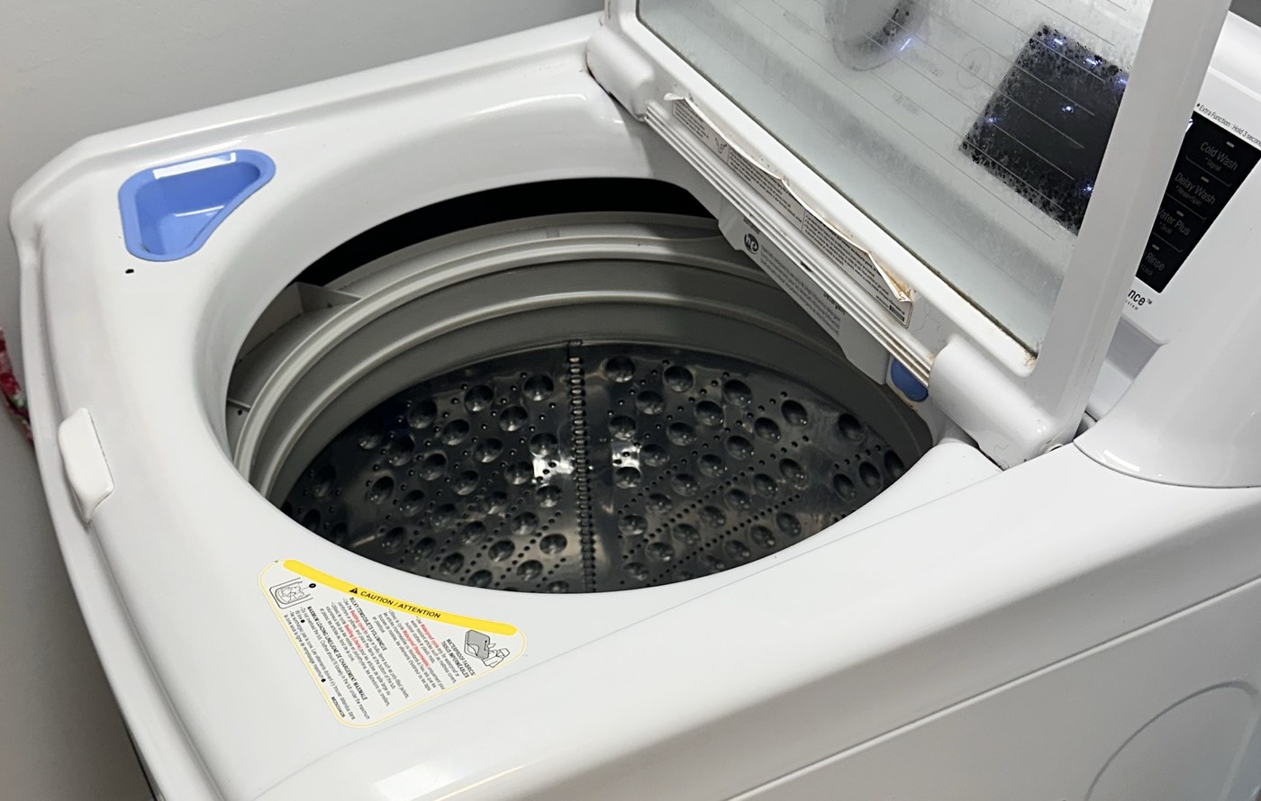 Open lid and stainless-steel wash basket of an LG WT7100CW washer in Cape Coral.